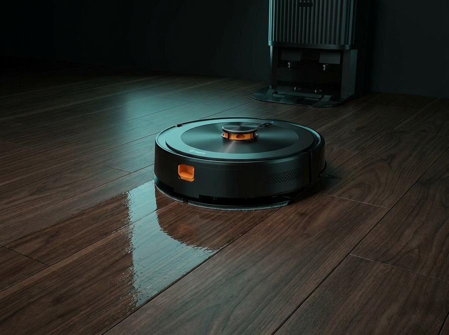 Robot vacuum mopping a dark wood floor